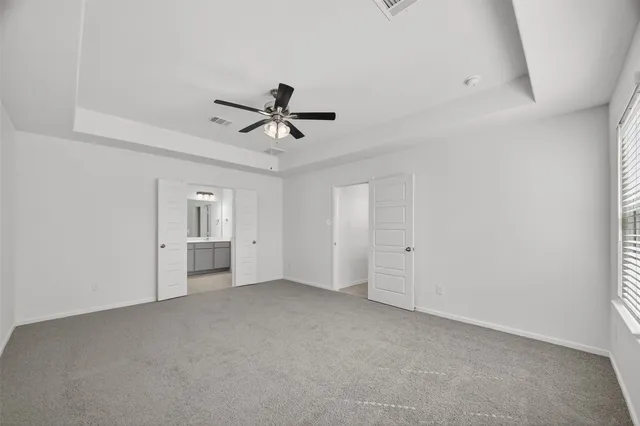 a view of a livingroom with a ceiling fan and wooden floor