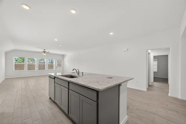 a kitchen with a sink cabinets and wooden floor