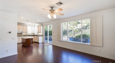 a view of a large kitchen with wooden floor and a window