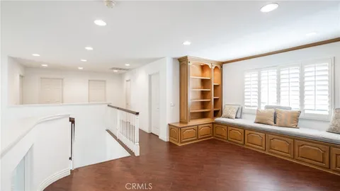 an empty room with chandelier fan and windows