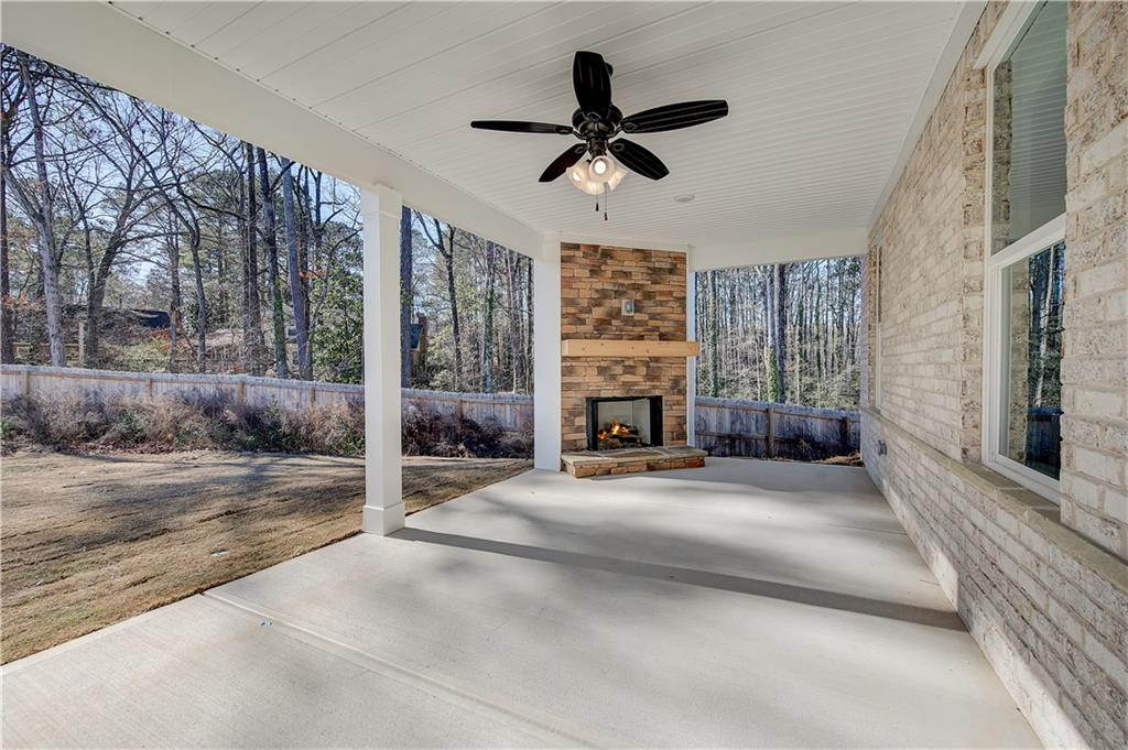 309 Exeter Court Stockbridge, GA 30281 - Photo 18 of 34 a view of a livingroom with a fireplace a ceiling fan and windows