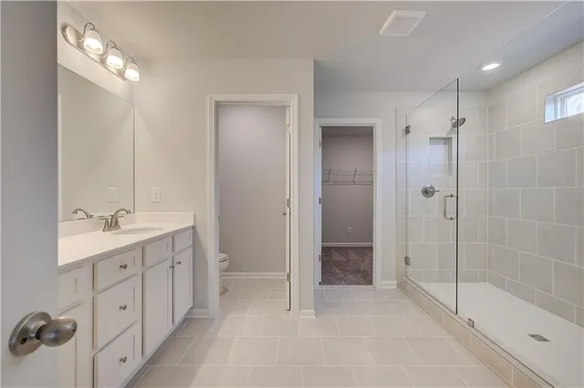 a spacious bathroom with a shower sink and mirror