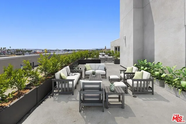 a view of a balcony with chairs and a potted plant