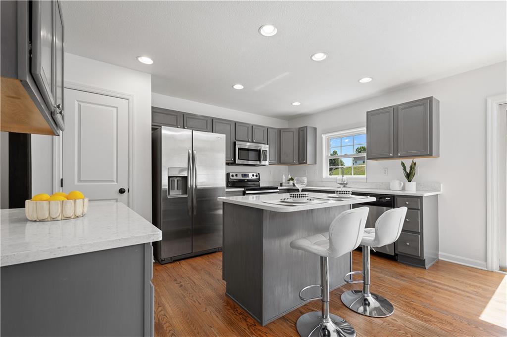 313 Hickory Nut Drive Eighty Four, PA 15330 - Photo 8 of 33 a kitchen with stainless steel appliances granite countertop a refrigerator a sink dishwasher a stove top oven a dining table and chairs with wooden floor