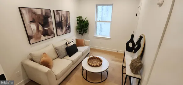 a living room with furniture and a painting on the wall