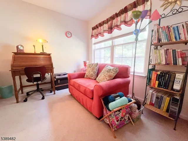 a living room with furniture a rug and white walls
