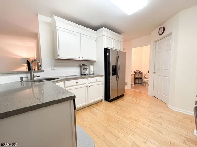 a kitchen with stainless steel appliances granite countertop a sink refrigerator and cabinets