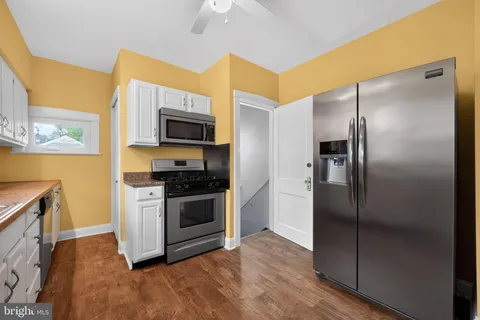 a kitchen with granite countertop a refrigerator and a stove top oven