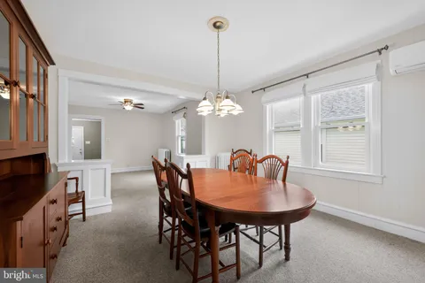 a dining room with furniture a chandelier and window