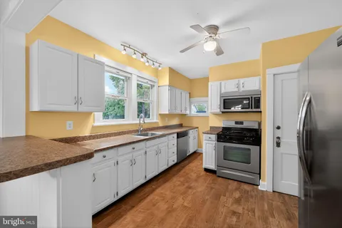 a kitchen with stainless steel appliances granite countertop a stove sink and cabinets