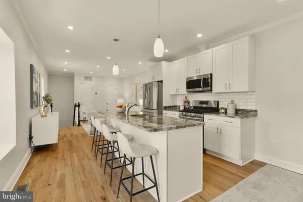 a kitchen with stainless steel appliances kitchen island granite countertop a sink and cabinets