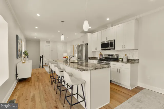 a kitchen with stainless steel appliances kitchen island granite countertop a sink and cabinets