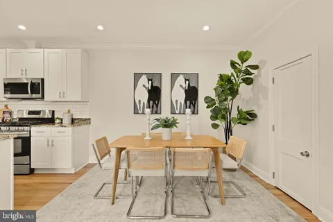 a dining room filled chandelier and kitchen view