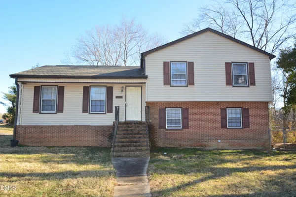 a view of a house with a yard balcony and a tree