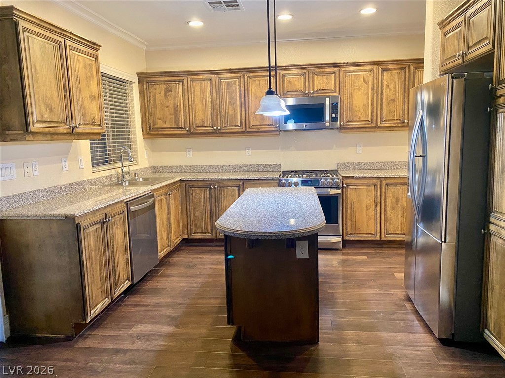 159 Tall Ruff Drive Las Vegas, NV 89148 - Photo 26 of 31 Rich wood cabinets and granite countertops surround a practical kitchen island under recessed lighting.