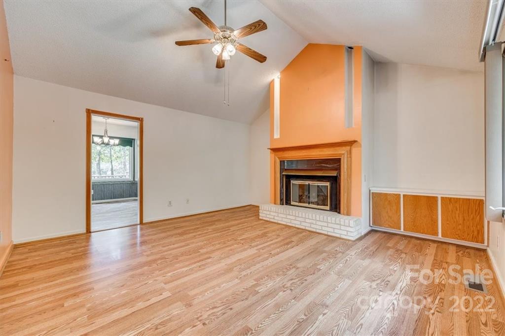 6036 Agate Court Tega Cay, SC 29708 - Photo 7 of 44 an empty room with windows chandelier fan and a fireplace