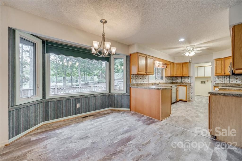 6036 Agate Court Tega Cay, SC 29708 - Photo 9 of 44 a open kitchen with stainless steel appliances granite countertop a refrigerator a stove top oven a sink dishwasher and wooden cabinets