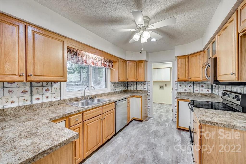 6036 Agate Court Tega Cay, SC 29708 - Photo 10 of 44 a kitchen with stainless steel appliances granite countertop a sink a stove cabinets counter space and a window