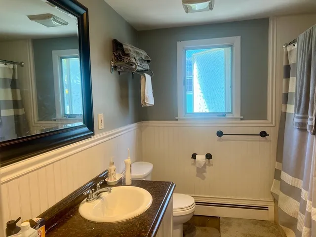 a bathroom with a sink mirror vanity and toilet
