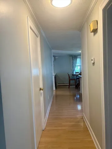 a view of a hallway with wooden floor windows and a livingroom