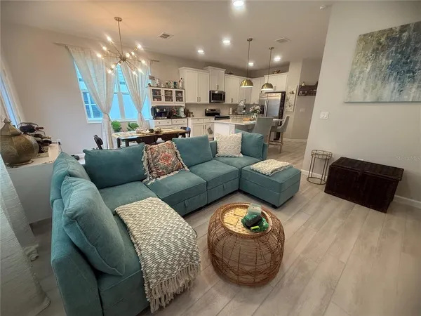 a kitchen with stainless steel appliances a dining table chairs refrigerator and sink