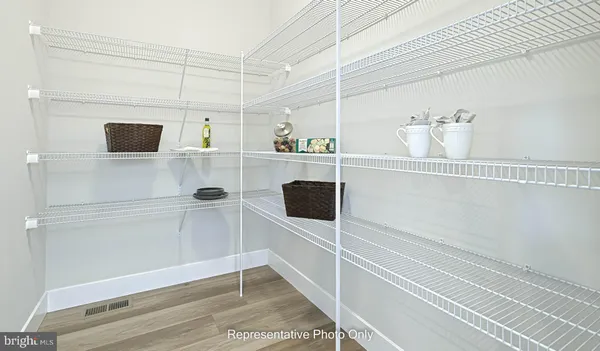a view of kitchen and empty room with wooden floor