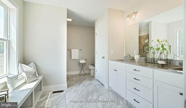 a spacious bathroom with a granite countertop sink and a mirror