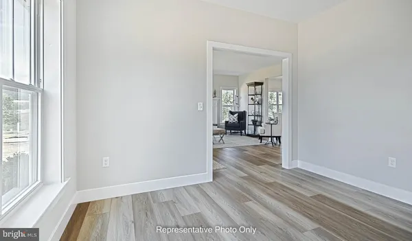 a view of a hallway view with wooden floor and a living room