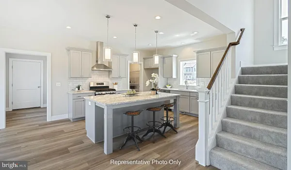 a kitchen with stainless steel appliances kitchen island a table chairs in it and wooden floors