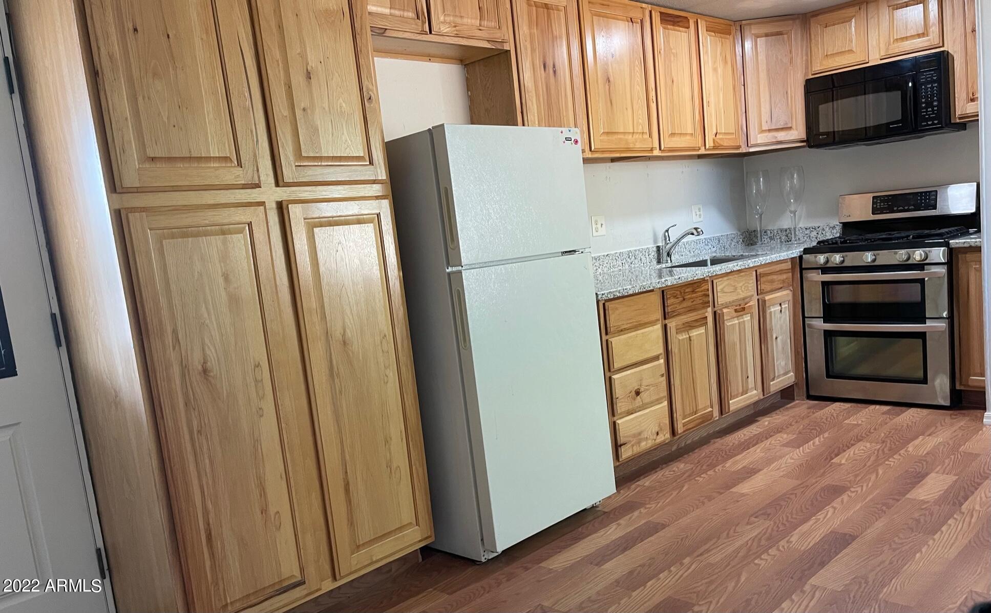 5201 West Camelback Road, Unit A7 Phoenix, AZ 85031 - Photo 11 of 22 a kitchen with stainless steel appliances a refrigerator and a stove top oven