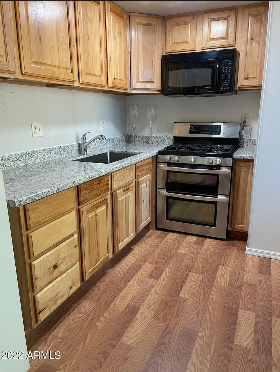 5201 West Camelback Road, Unit A7 Phoenix, AZ 85031 - Photo 12 of 22 a kitchen with stainless steel appliances granite countertop a stove microwave and sink