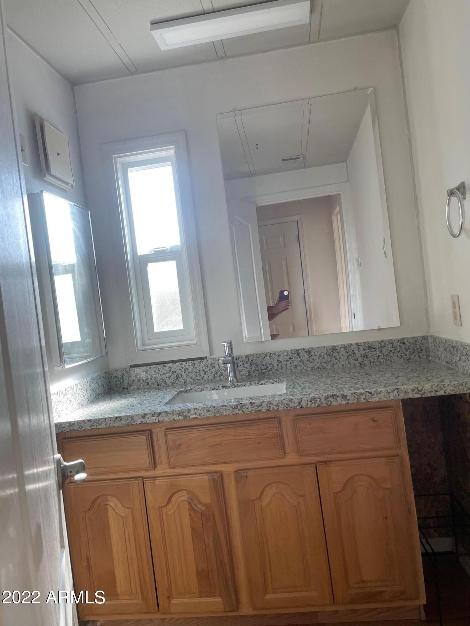 5201 West Camelback Road, Unit A7 Phoenix, AZ 85031 - Photo 20 of 22 a bathroom with a granite countertop sink and a mirror