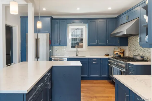 a kitchen with stainless steel appliances granite countertop a sink stove and refrigerator