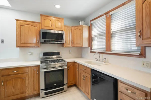 a kitchen with stainless steel appliances a stove sink microwave and cabinets
