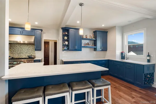 a kitchen with stainless steel appliances kitchen island granite countertop a table chairs sink and cabinets