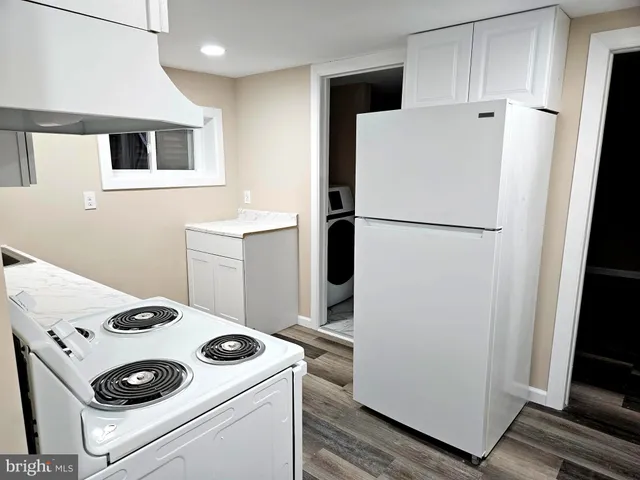 a white refrigerator freezer and a stove sitting inside of a kitchen