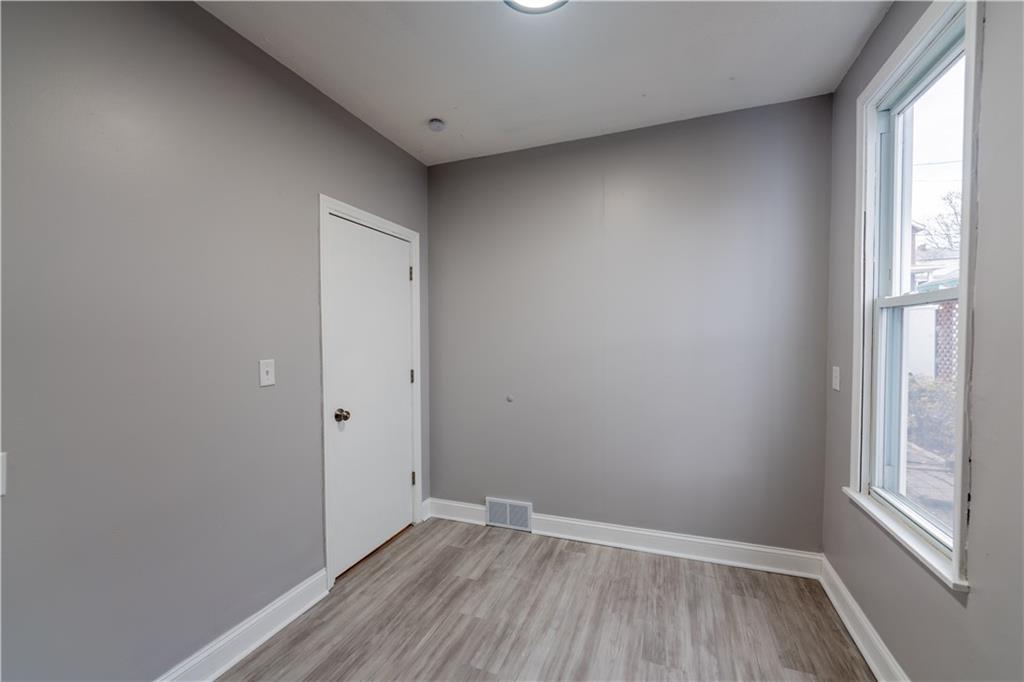 519 Lacock Street Rochester, PA 15074 - Photo 11 of 39 a view of an empty room with wooden floor and a window