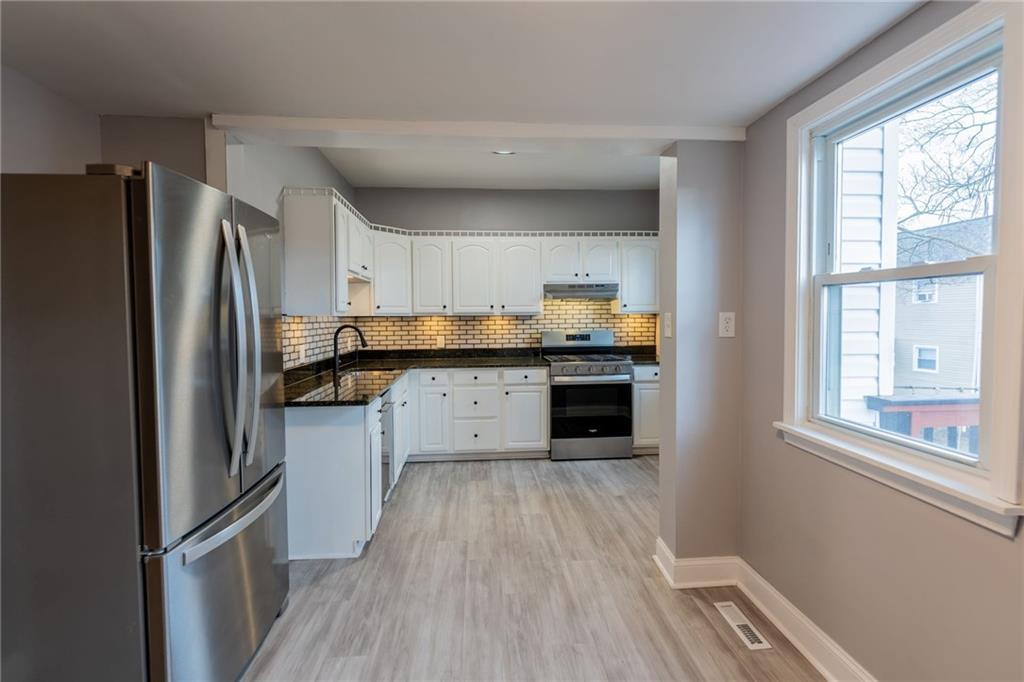 519 Lacock Street Rochester, PA 15074 - Photo 13 of 39 a kitchen with granite countertop stainless steel appliances a refrigerator cabinets and wooden floor