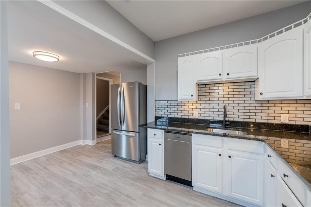 519 Lacock Street Rochester, PA 15074 - Photo 14 of 39 a kitchen with stainless steel appliances granite countertop a sink and a refrigerator