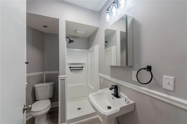 a bathroom with a toilet sink and mirror