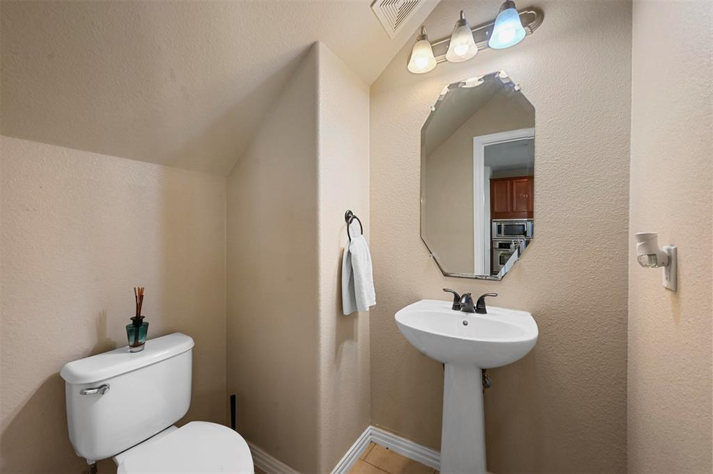 14815 Frisco Ranch Drive Little Elm, TX 75068 - Photo 19 of 40 a bathroom with a toilet sink and mirror