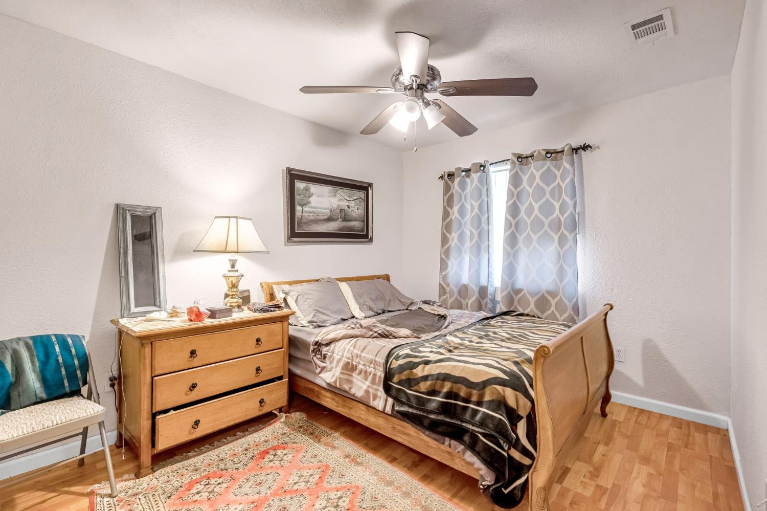 1622 B Street Fresno, CA 93706 - Photo 31 of 32 a bedroom with a bed and a chandelier