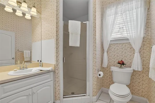 a bathroom with a sink a mirror a toilet and a shower