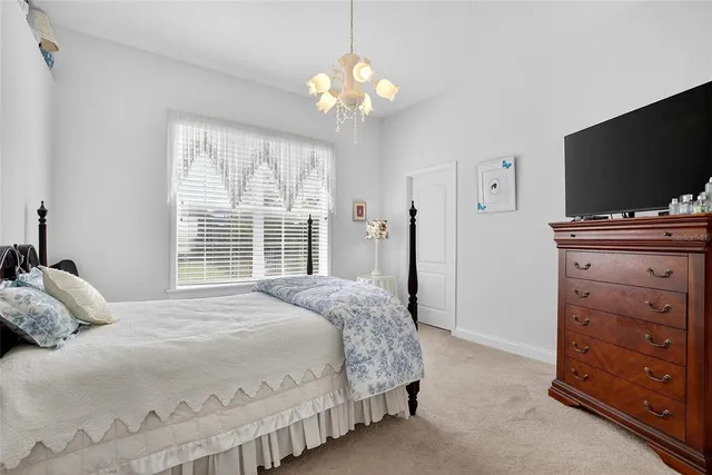 a bedroom with a bed and a flat tv screen on dresser