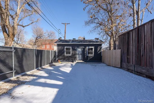 a view of a house with wooden fence and a pathway