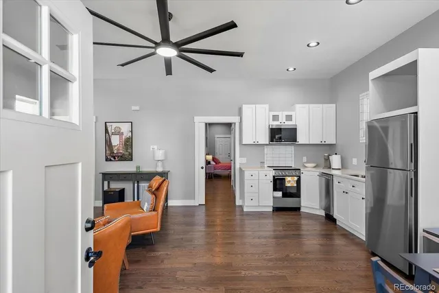 a kitchen with stainless steel appliances refrigerator stove and wooden floor