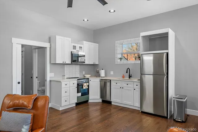 a kitchen with stainless steel appliances granite countertop a refrigerator stove and sink