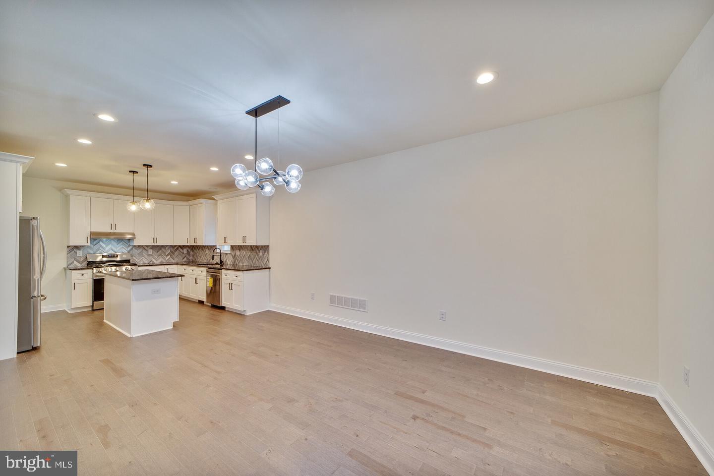 274 Oak Avenue Media, PA 19063 - Photo 12 of 27 a open kitchen with a sink dishwasher a kitchen island a stove with white cabinets and chandelier