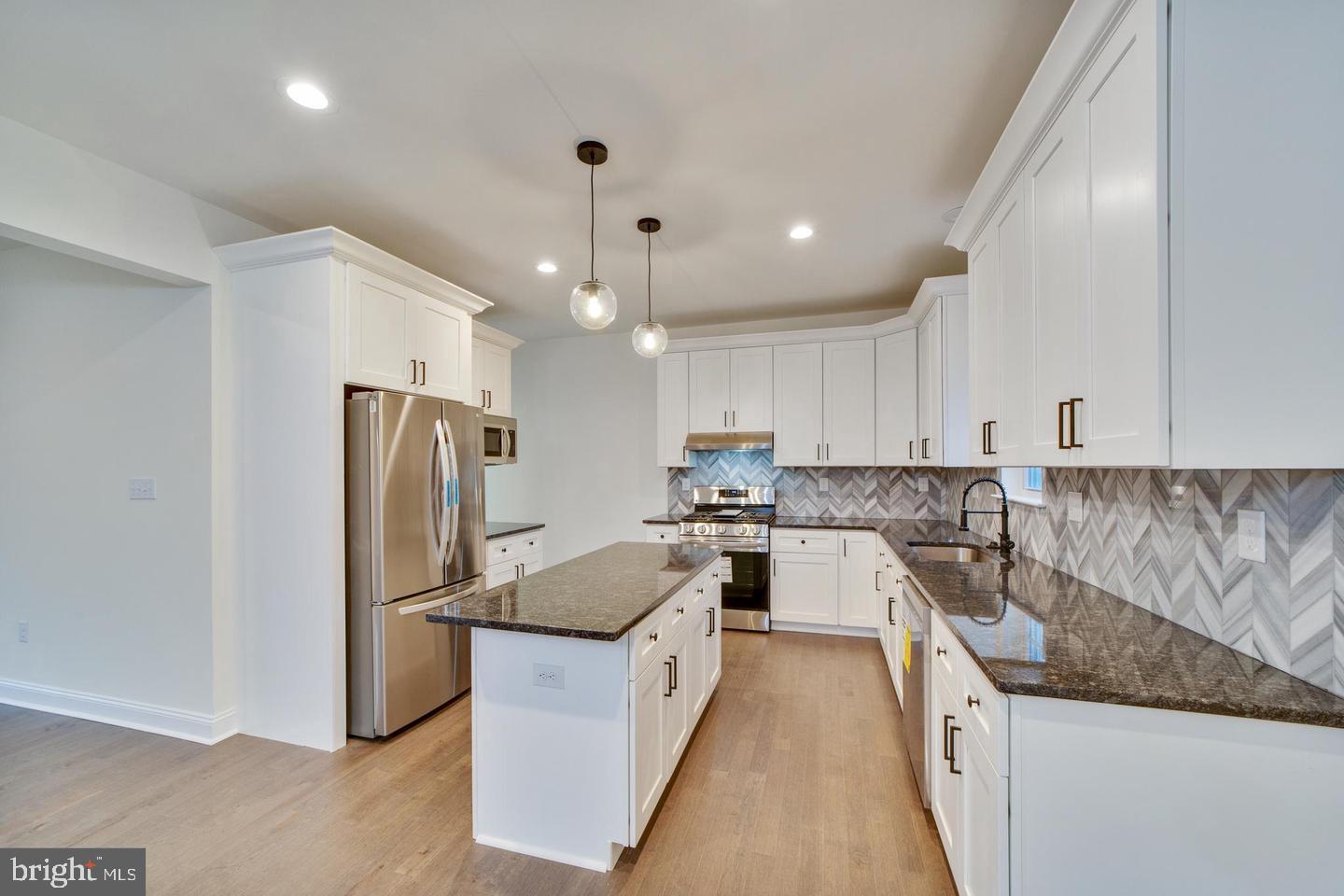 274 Oak Avenue Media, PA 19063 - Photo 5 of 27 a kitchen with a refrigerator a sink and a stove top oven with wooden floor