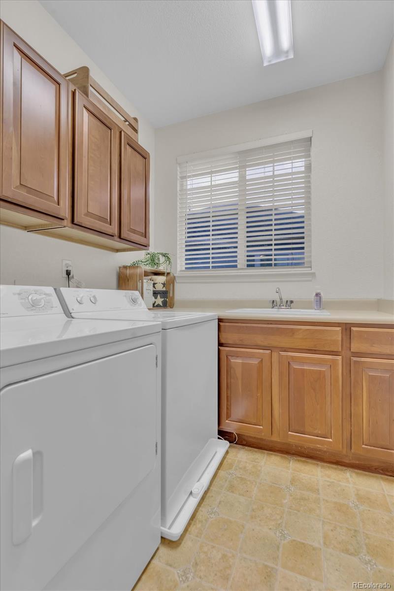 4786 Rabbit Mountain Road Broomfield, CO 80020 - Photo 30 of 41 a utility room with cabinets washer and dryer